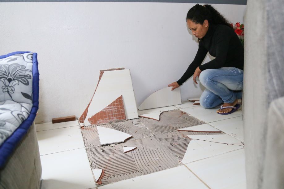 Nilvania mostra o estrago causado no piso do apartamento em que mora com os três fihos | Foto: Eduardo Montecino/OCP 