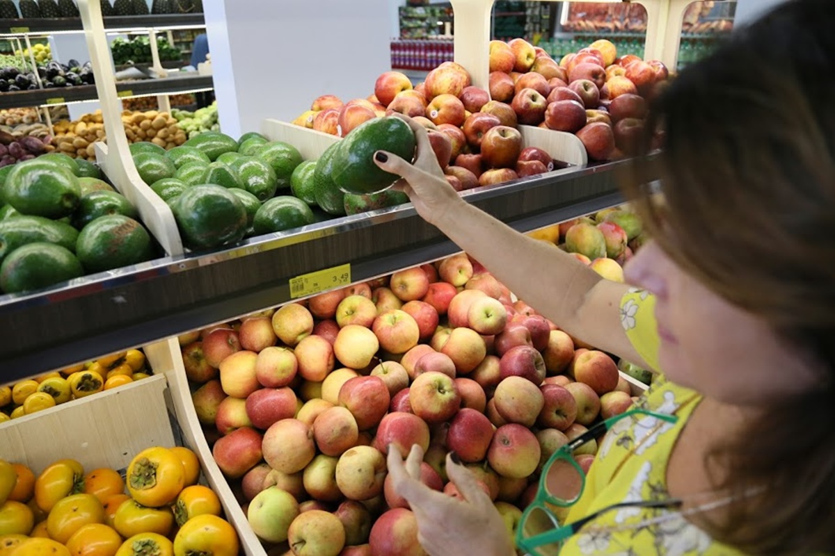 Mulher escolhe frutas no mercado