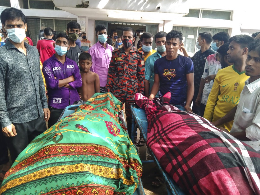 Pessoas ao redor de corpos de vítimas de um raio na cidade de Shibganj, em Bangladesh, em 4 de agosto de 2021 — Foto: Md Jahangir Alom/AP

